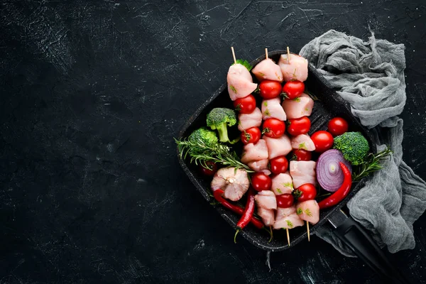 Kiraz domates ile çiğ tavuk şiş kebap. Barbekü. Siyah taş arka planda. Üst görünüm. Ücretsiz kopya alanı.