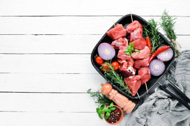 Çiğ şap kebabı. baharat ve otlar ile barbekü et. Beyaz ahşap bir arka planda. Üst görünüm. Ücretsiz kopya alanı.