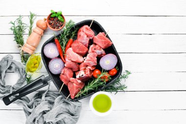 Çiğ şap kebabı. baharat ve otlar ile barbekü et. Beyaz ahşap bir arka planda. Üst görünüm. Ücretsiz kopya alanı.