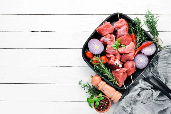 Çiğ şap kebabı. baharat ve otlar ile barbekü et. Beyaz ahşap bir arka planda. Üst görünüm. Ücretsiz kopya alanı.