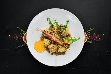 Karides ve deniz ürünleri ile ravioli. İtalyan mutfağı. Köfte. Ahşap bir arka planda bir plaka içinde. Üst görünüm. Ücretsiz kopya alanı.