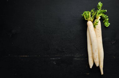 Radish Daikon siyah bir arka planda. Turp. Sebze. Üst görünüm. Metniniz için boş alan.