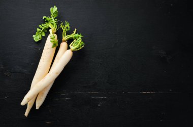 Radish Daikon siyah bir arka planda. Turp. Sebze. Üst görünüm. Metniniz için boş alan.