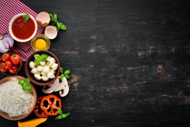 Pizza yapmak için malzemeler. Ahşap bir arka planda. Üst görünüm. Metniniz için boş alan.