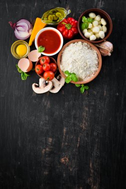 Pizza yapmak için malzemeler. Ahşap bir arka planda. Üst görünüm. Metniniz için boş alan.