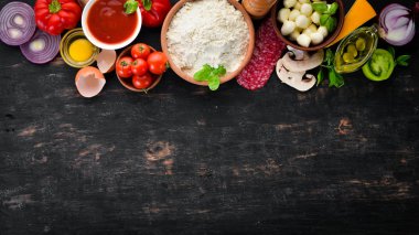 Pizza yapmak için malzemeler. Ahşap bir arka planda. Üst görünüm. Metniniz için boş alan.