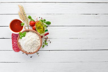 Pizza yapmak için malzemeler. Ahşap bir arka planda. Üst görünüm. Metniniz için boş alan.