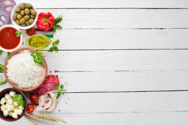 Pizza yapmak için malzemeler. Ahşap bir arka planda. Üst görünüm. Metniniz için boş alan.