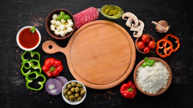 Pizza yapmak için malzemeler. Ahşap bir arka planda. Üst görünüm. Metniniz için boş alan.