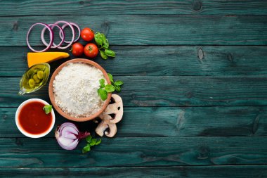 Pizza yapmak için malzemeler. Ahşap bir arka planda. Üst görünüm. Metniniz için boş alan.