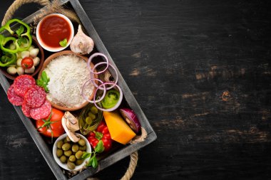 Ahşap bir kutuda pizza için malzemeler. Üst görünüm. Ahşap bir arka planda. Ücretsiz kopya alanı.