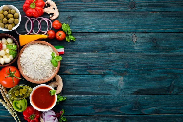 Pizza yapmak için malzemeler. Ahşap bir arka planda. Üst görünüm. Metniniz için boş alan.