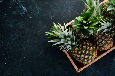 Ahşap bir kutuda ananas. Tropikal meyveler. Üst görünüm. Ücretsiz kopya alanı