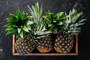 Ahşap bir kutuda ananas. Tropikal meyveler. Üst görünüm. Ücretsiz kopya alanı