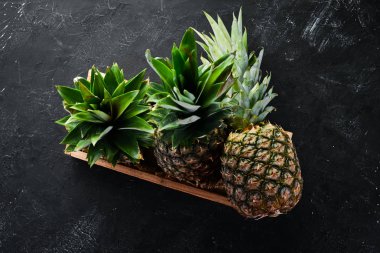 Ahşap bir kutuda ananas. Tropikal meyveler. Üst görünüm. Ücretsiz kopya alanı