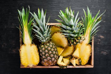 Ahşap bir kutuda ananas. Tropikal meyveler. Üst görünüm. Ücretsiz kopya alanı