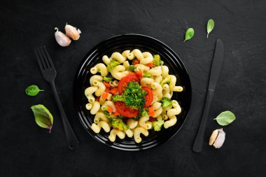 Sebzeli Makarna. Siyah bir arka planda. Üst görünüm. Metniniz için boş alan.
