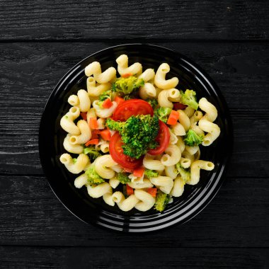 Sebzeli Makarna. Siyah bir arka planda. Üst görünüm. Metniniz için boş alan.