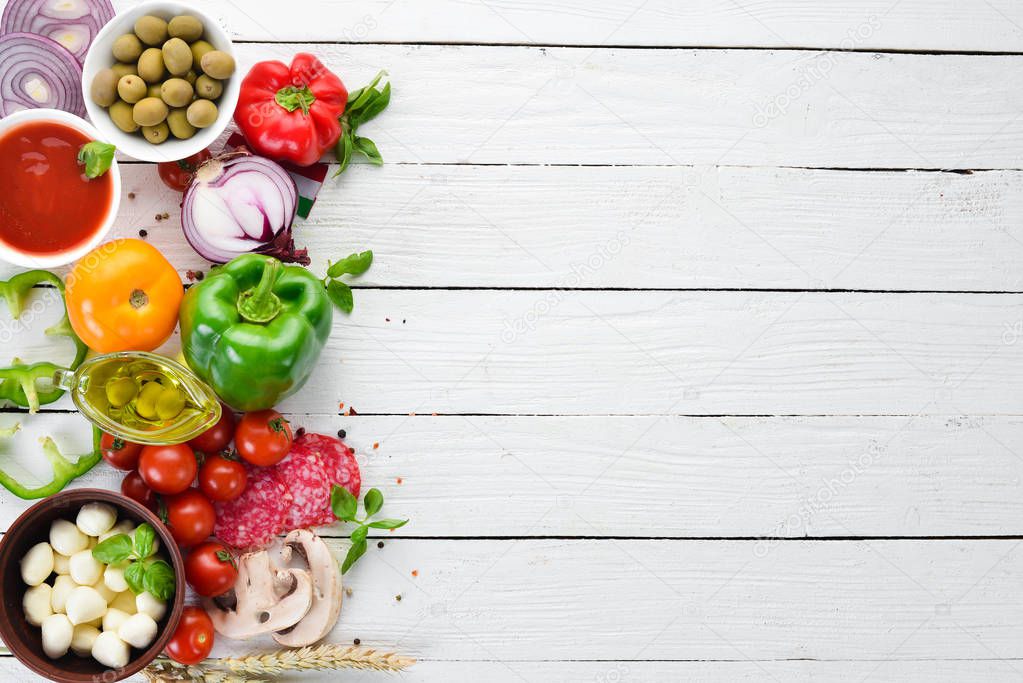 Food Background. Mushrooms, cheese, sausages, tomatoes, vegetables. Top view. On a wooden background. Free copy space.