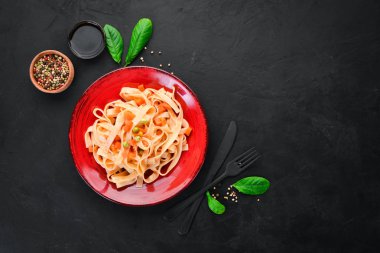 Bir tabak içinde sebze ve domates sosu ile makarna. Eski arka planda. Üst görünüm. Metniniz için boş alan.