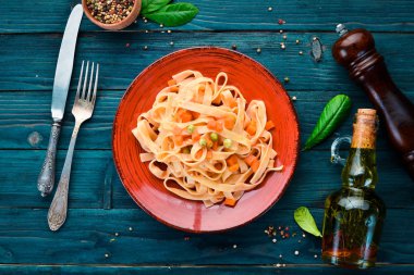 Bir tabak içinde sebze ve domates sosu ile makarna. Eski arka planda. Üst görünüm. Metniniz için boş alan.