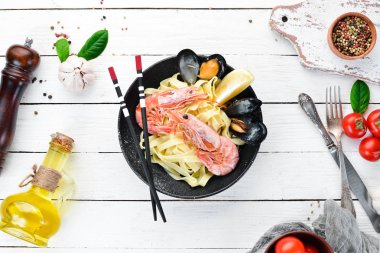 Bir tabak içinde deniz ürünleri ve limon ile makarna. Karides, midye. Eski arka planda. Üst görünüm. Metniniz için boş alan.