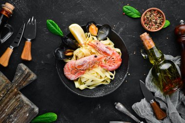 Bir tabak içinde deniz ürünleri ve limon ile makarna. Karides, midye. Eski arka planda. Üst görünüm. Metniniz için boş alan.