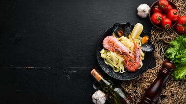 Bir tabak içinde deniz ürünleri ve limon ile makarna. Karides, midye. Eski arka planda. Üst görünüm. Metniniz için boş alan.