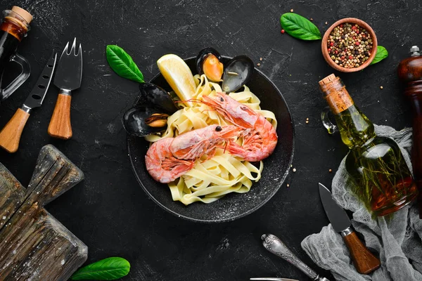 Bir tabak içinde deniz ürünleri ve limon ile makarna. Karides, midye. Eski arka planda. Üst görünüm. Metniniz için boş alan.