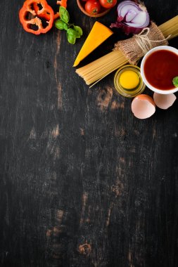 Makarna pişirmek için malzemeler. Kuru makarna. Mantar, sosis, domates, sebze. Üst görünüm. Siyah ahşap bir arka planda. Ücretsiz kopya alanı.