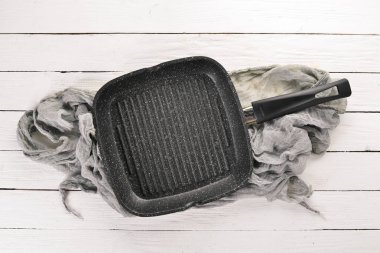 Pişirme için ızgara tava. Siyah taş arka planda. Üst görünüm. Ücretsiz kopya alanı.