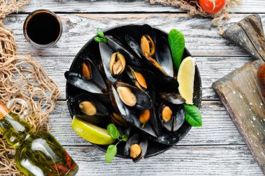 Bir tabak baharatlar ile haşlanmış midye. Üst görünüm. Metniniz için boş alan. Eski arka planda.