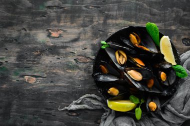 Bir tabak baharatlar ile haşlanmış midye. Üst görünüm. Metniniz için boş alan. Eski arka planda.