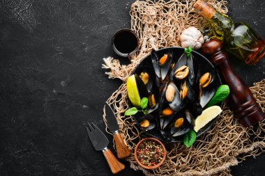 Bir tabak baharatlar ile haşlanmış midye. Üst görünüm. Metniniz için boş alan. Eski arka planda.