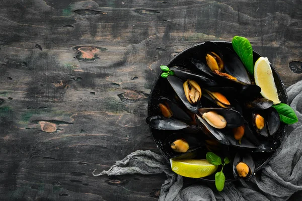 Bir tabak baharatlar ile haşlanmış midye. Üst görünüm. Metniniz için boş alan. Eski arka planda.