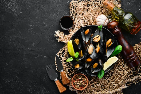 Bir tabak baharatlar ile haşlanmış midye. Üst görünüm. Metniniz için boş alan. Eski arka planda.