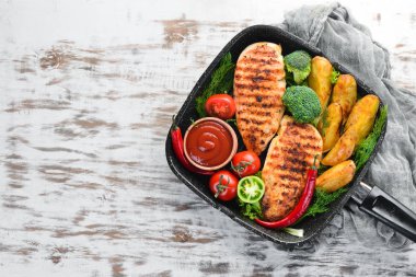 Siyah taş arka planda havuç ve sebze ile pişmiş tavuk fileto. Üst görünüm. Ücretsiz kopya alanı.