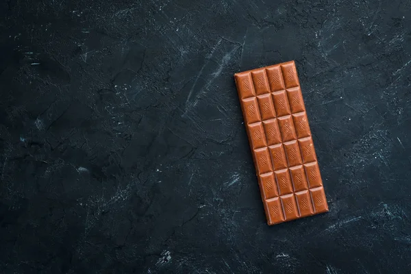 Dark chocolate on a black background. Top view. Free copy space.
