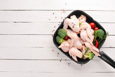 Çiğ tavuk kanatları. Siyah taş arka planda. Üst görünüm. Ücretsiz kopya alanı.