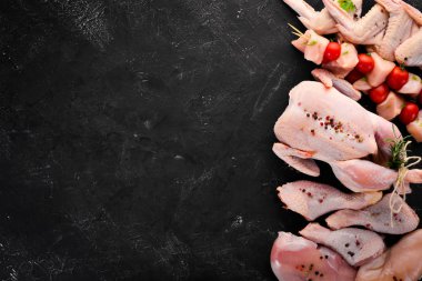 Tavuk eti seti. Siyah taş bir arka plan üzerinde. Üst te. Ücretsiz kopyalama alanı.