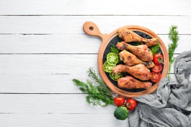 Beyaz ahşap arka plan üzerinde Pişmiş Tavuk bacaklar. Et. Üst te. Ücretsiz kopyalama alanı