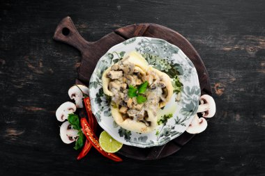 Mantar, peynir ve krema soslu krep. Ahşap bir arka plan üzerinde. Üst te. Metniniz için boş alan.