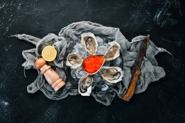 Bir tabak buz ve limonda istiridye ve kırmızı havyar. Deniz ürünleri. Üst te. Ücretsiz kopyalama alanı.