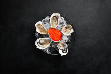 Bir tabak buz ve limonda istiridye ve kırmızı havyar. Deniz ürünleri. Üst te. Ücretsiz kopyalama alanı.