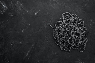 Siyah arka planda siyah spagetti. Üst te. Metniniz için boş alan.