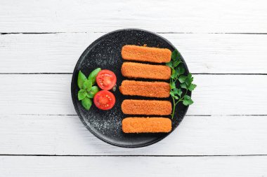 Fırında Balık Çubukları. Siyah bir arka plan üzerinde. Üst te. Ücretsiz kopyalama alanı.