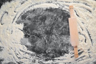 Pişirme nin arka planı. siyah bir arka plan üzerinde oklava ve un. Üst te. Ücretsiz kopyalama alanı.