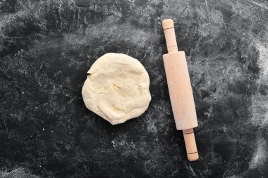 Pişirme nin arka planı. siyah bir arka plan üzerinde oklava ve un. Üst te. Ücretsiz kopyalama alanı.