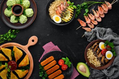 Asya yemeği ayarla. Erişte, karides, Samsa, khinkali. Siyah ahşap bir arka plan üzerinde. Üst te. Ücretsiz kopyalama alanı.