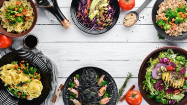 Yemek geçmişi. Makarna, pirinç, risotto, salata. Beyaz ahşap bir arka plan üzerinde. Ücretsiz kopyalama alanı.